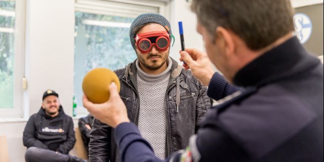 Polizeihauptkommissar Carsten Jahns simuliert mit einer Rauschbrille das Verhalten eines Autofahrers unter dem Einfluss von Alkohol und Drogen