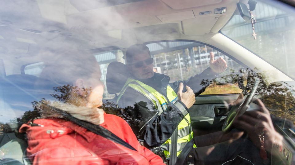 Polizeihauptkommissar Carsten Jahns im Gespräch mit einer jungen Autofahrerin