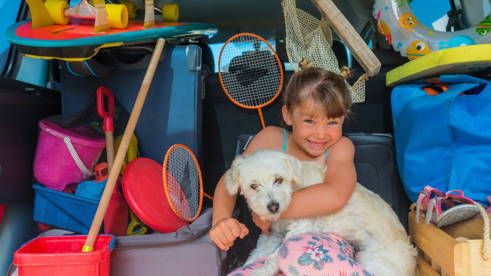 Überladener Kofferraum mit Gepäck, Kind und Hund